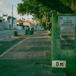 Rua tranquila de Guajará-Mirim, com vegetação e sinalização urbana.
