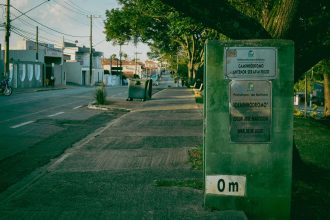 Rua tranquila de Guajará-Mirim, com vegetação e sinalização urbana.