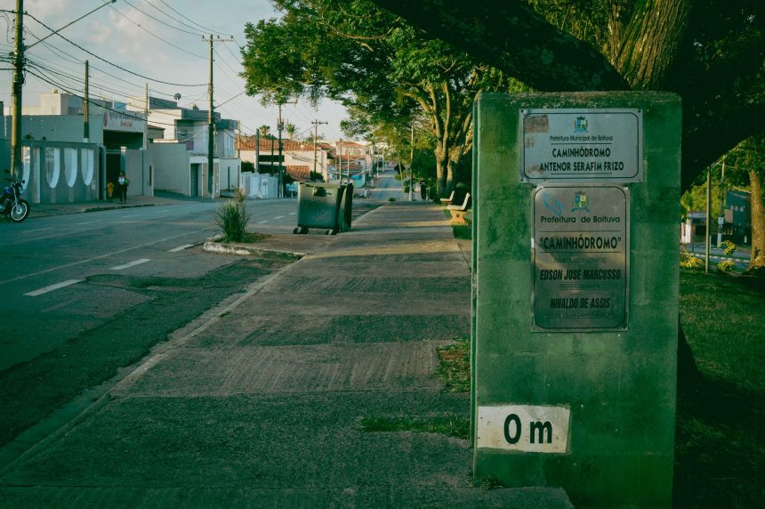 Rua tranquila de Guajará-Mirim, com vegetação e sinalização urbana.